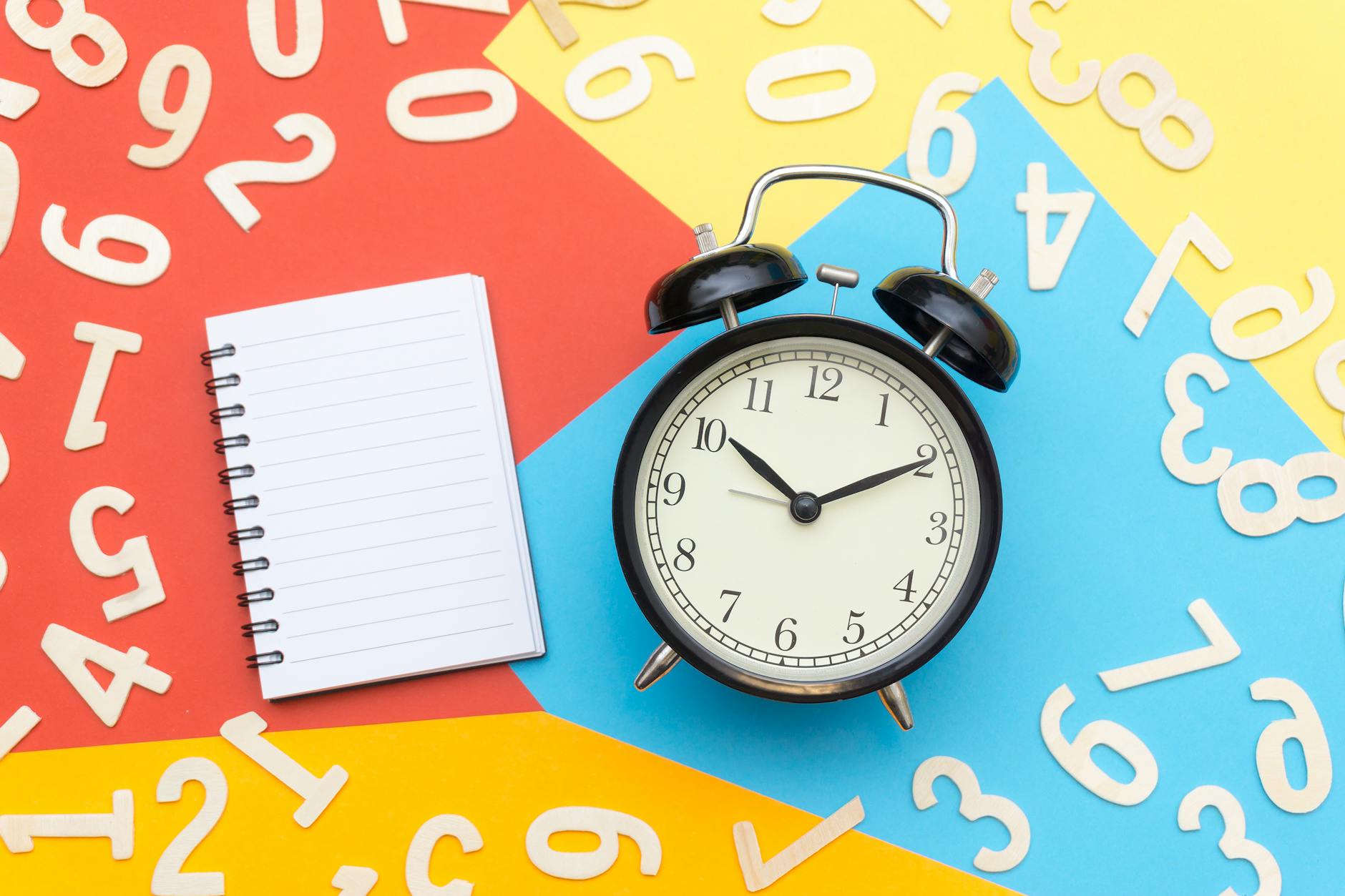 alarm clock lying on multicolored surface