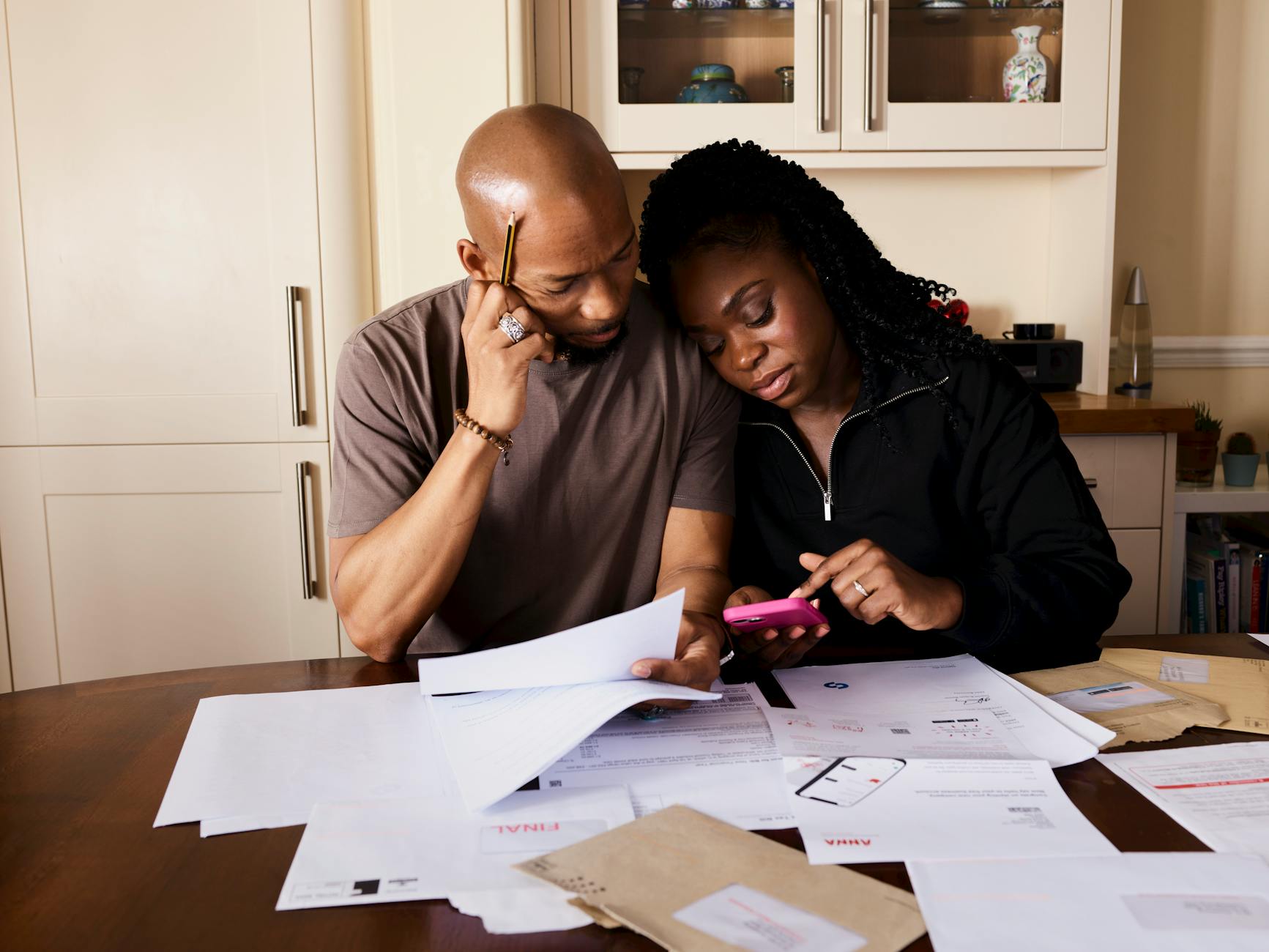 couple sitting by table calculating expenses