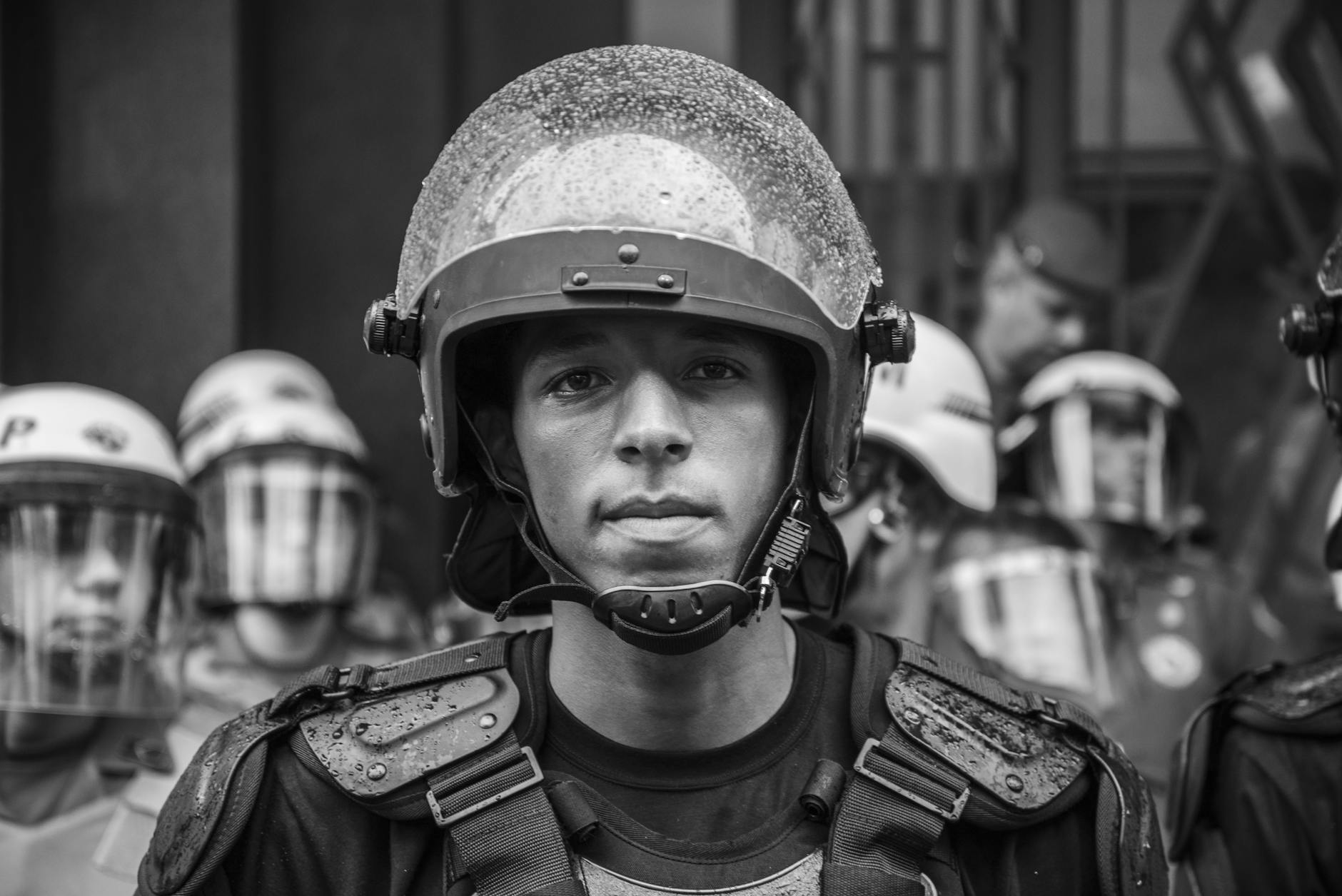 grayscale portrait photo of man wearing helmet