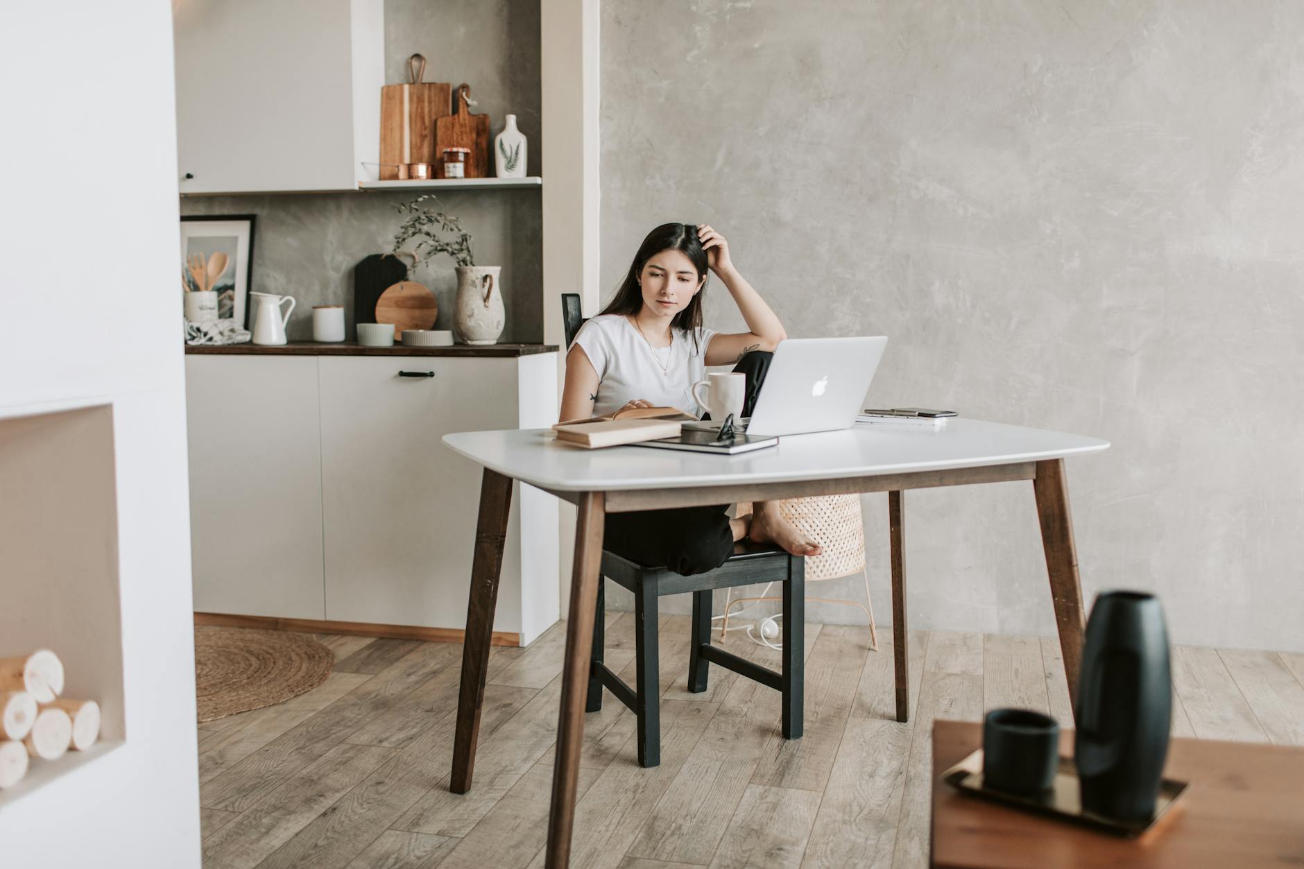 focused young woman with laptop and books at home