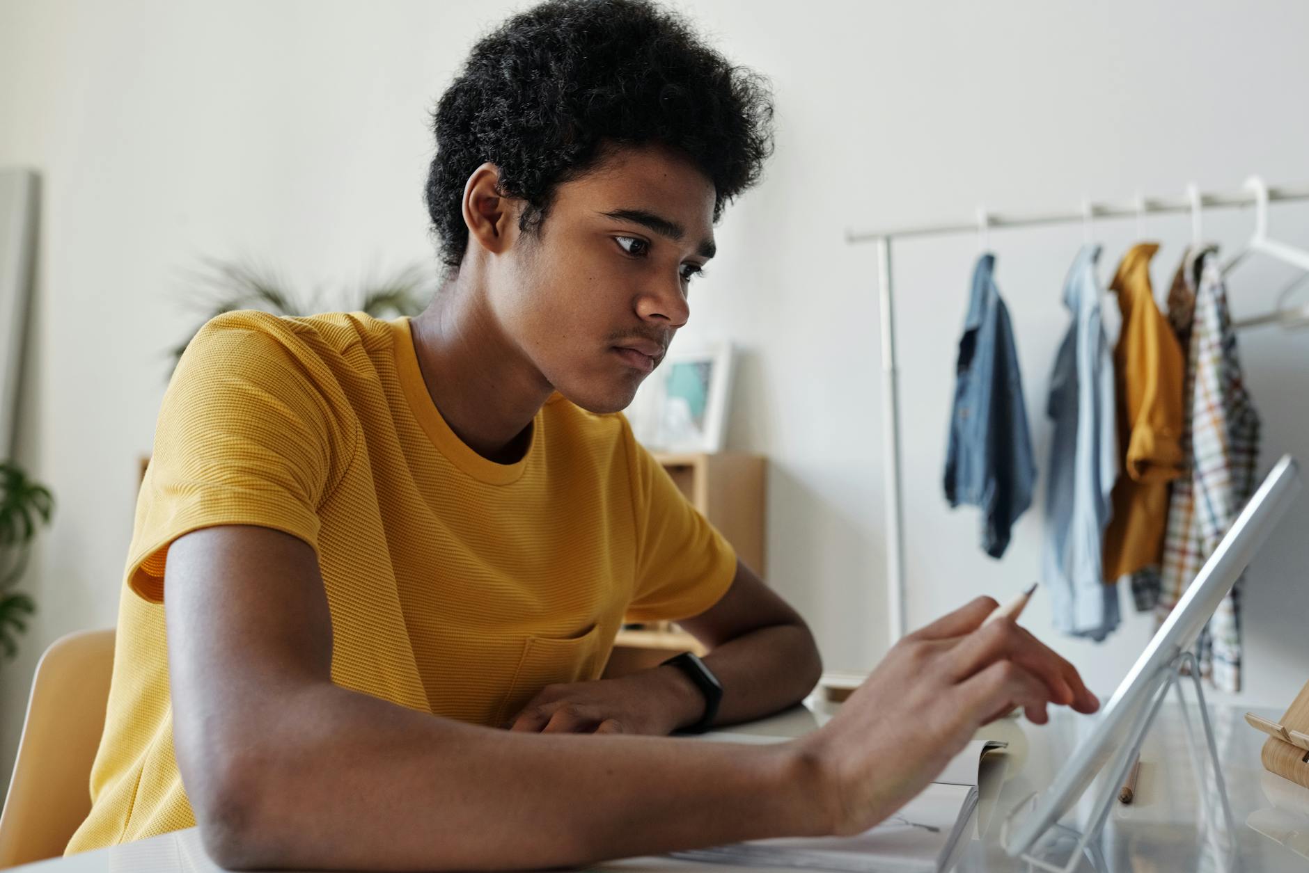 man in yellow crew neck t shirt while using tablet