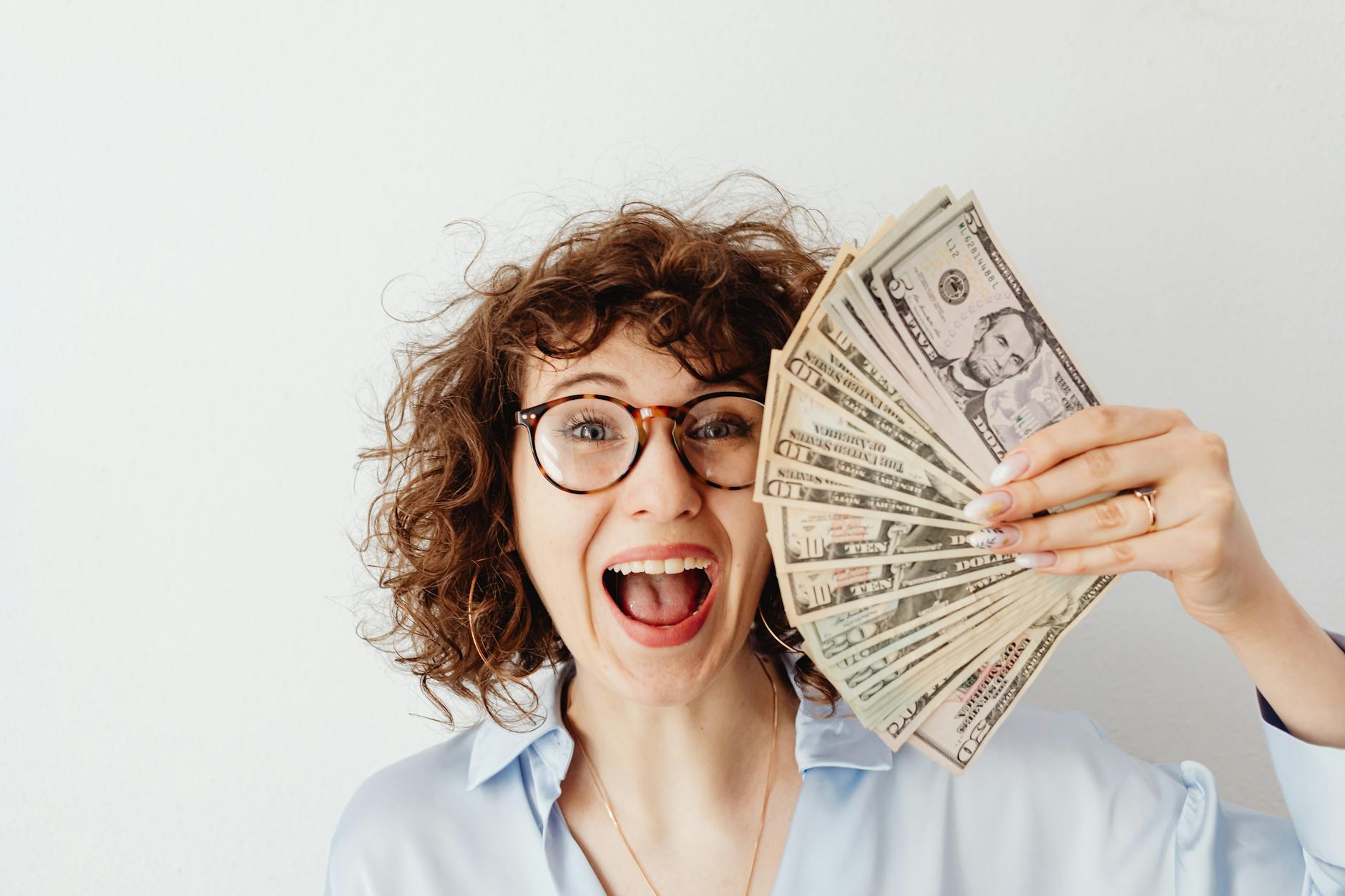 happy woman in blue long sleeve blouse holding money