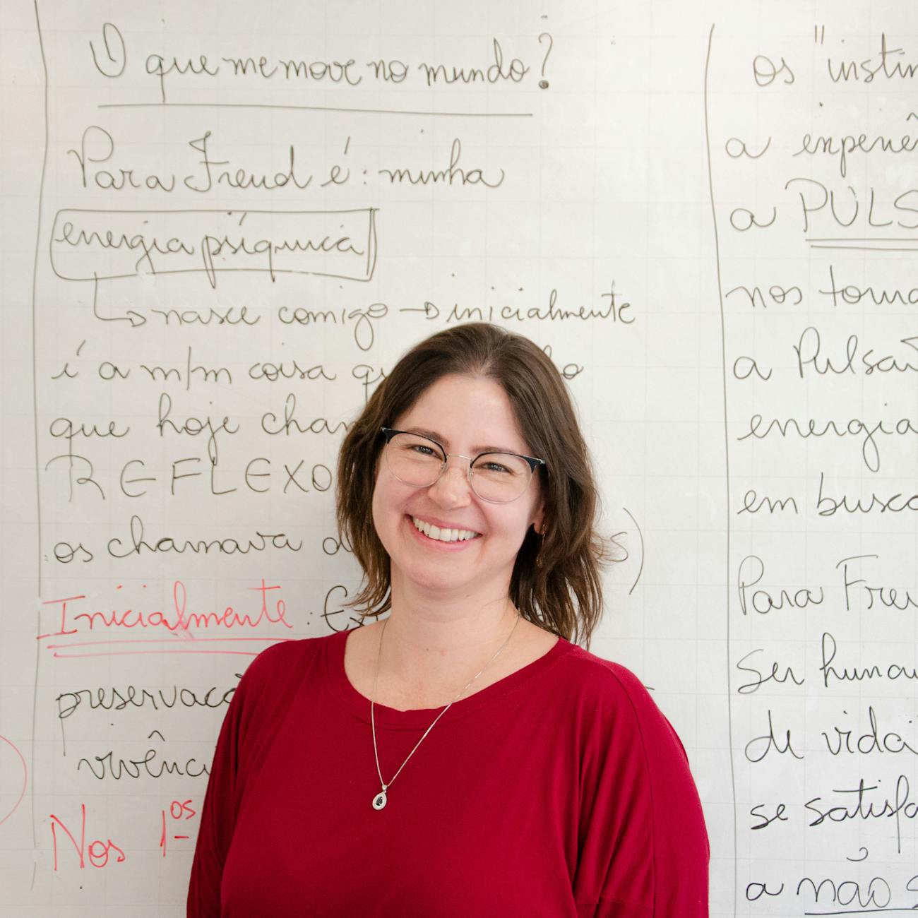 smiling teacher standing by whiteboard in classroom