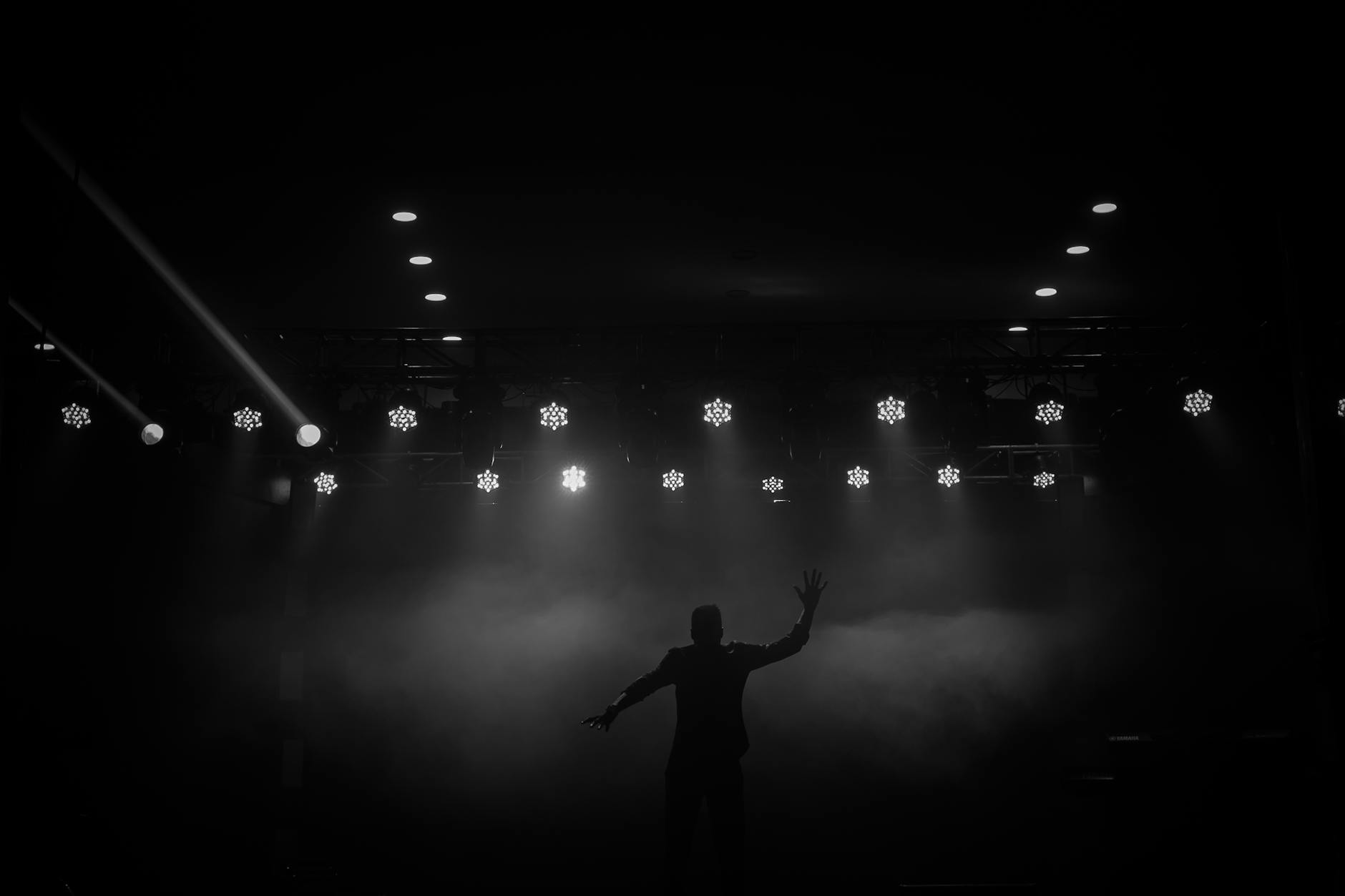 silhouette of performer on stage in dramatic lighting