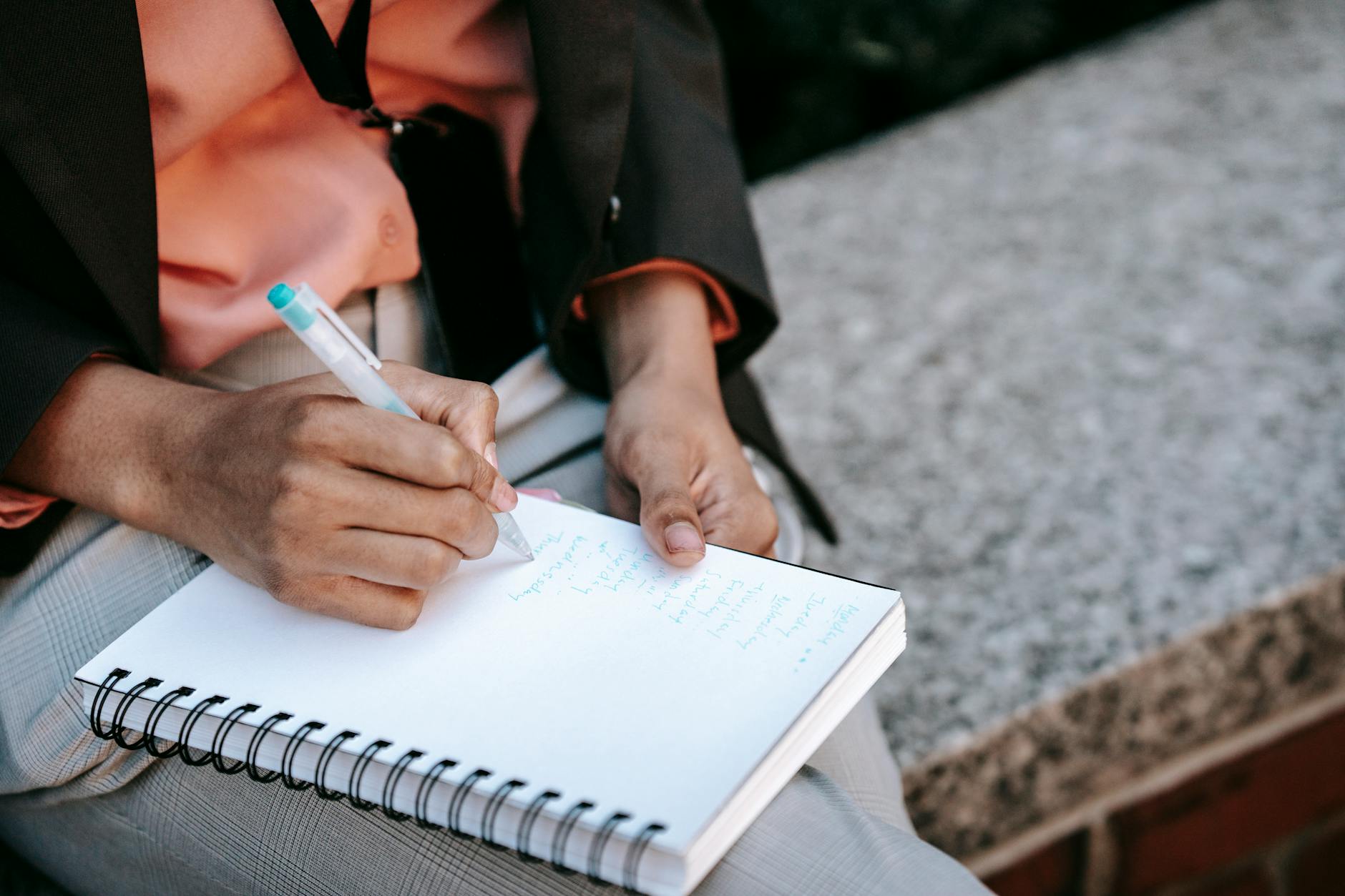 ethnic female employee writing list in notepad
