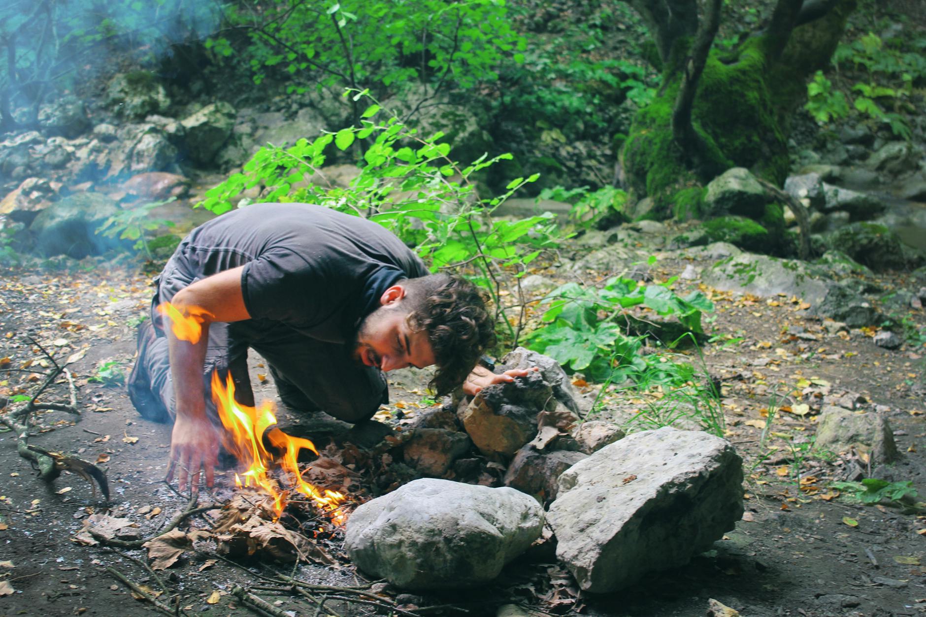man checking bonfire at forest