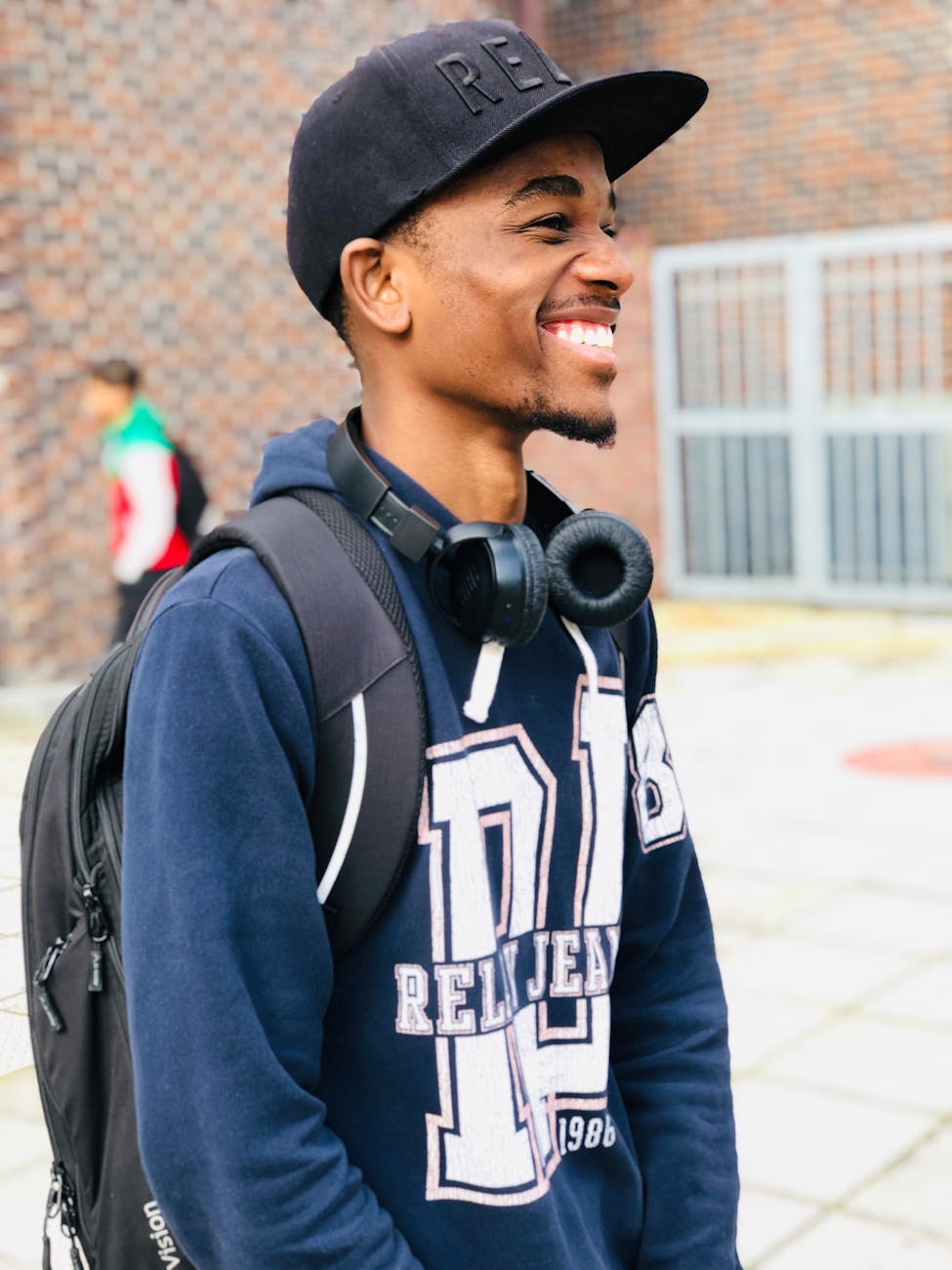 man wearing black cap blue hoodie and backpack