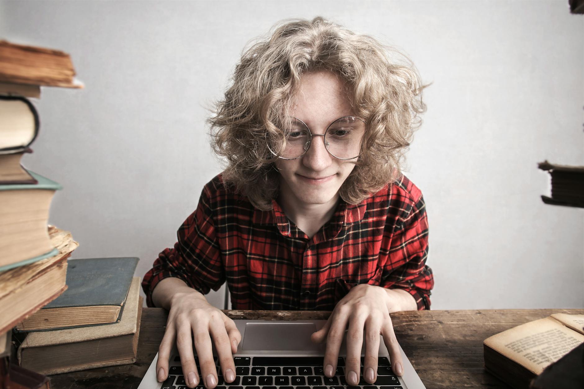content young male student using laptop in library