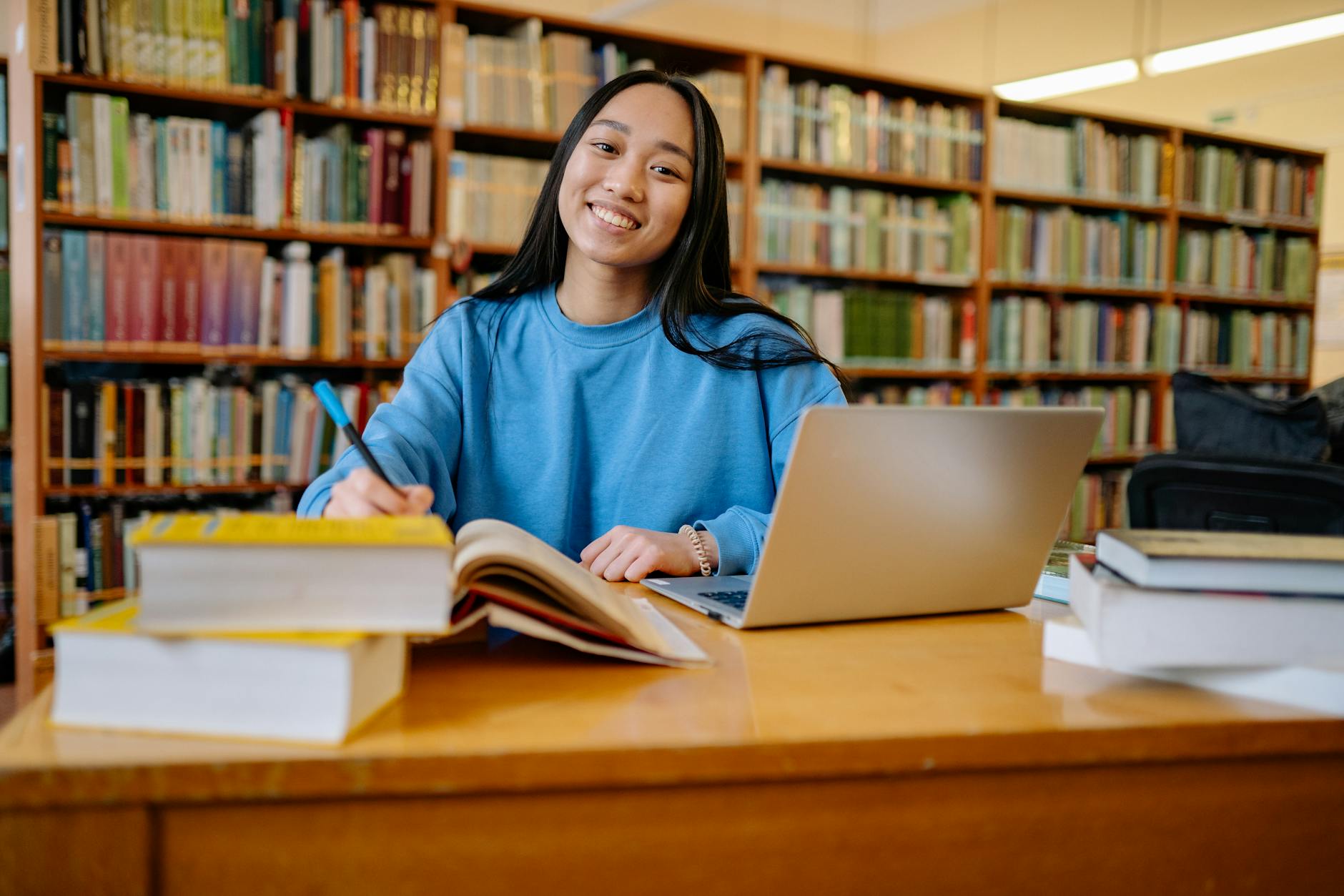 woman in blue long sleeve shirt sitting at the table smiling
