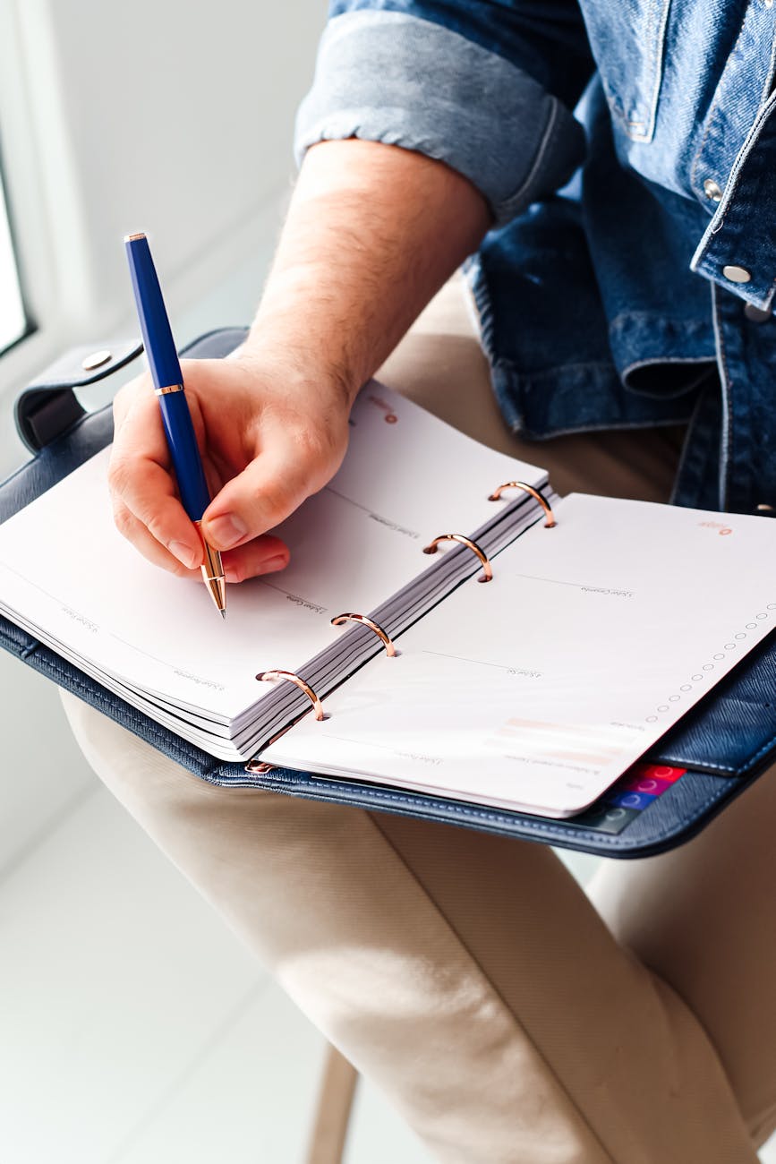 close up of hand writing in an organizer