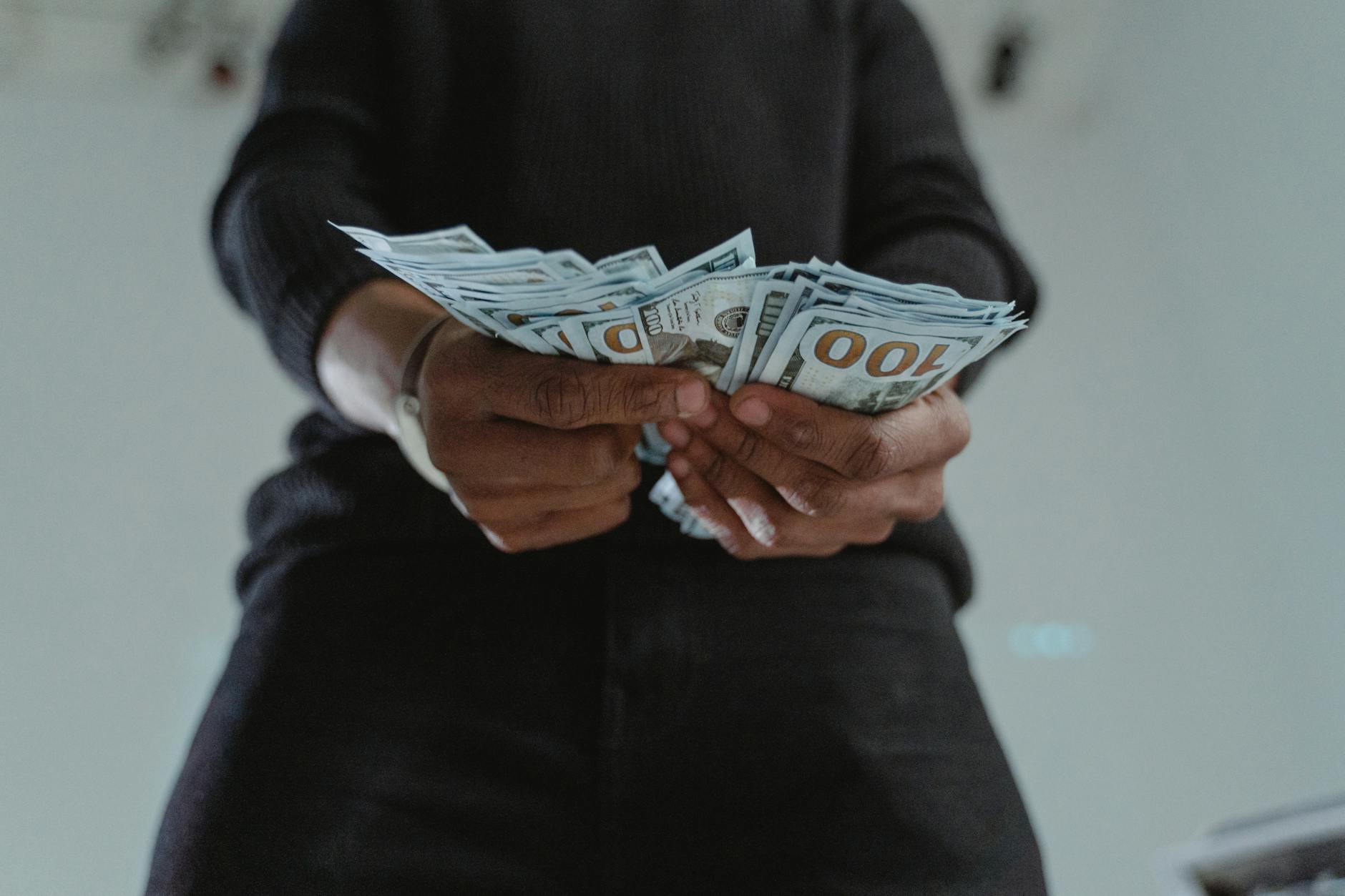 close up photo of a person s hands holding dollar bank notes