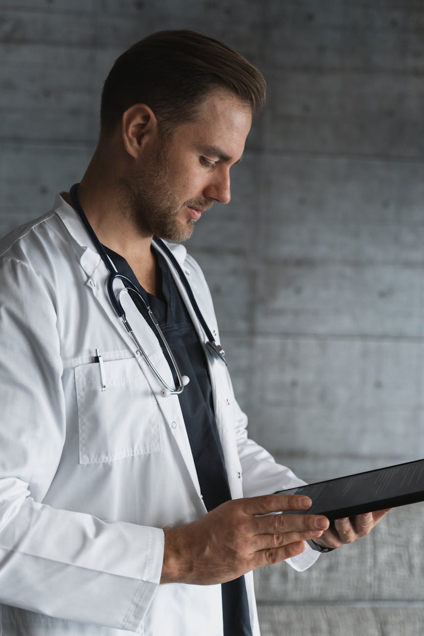 man in white button up shirt holding black tablet computer