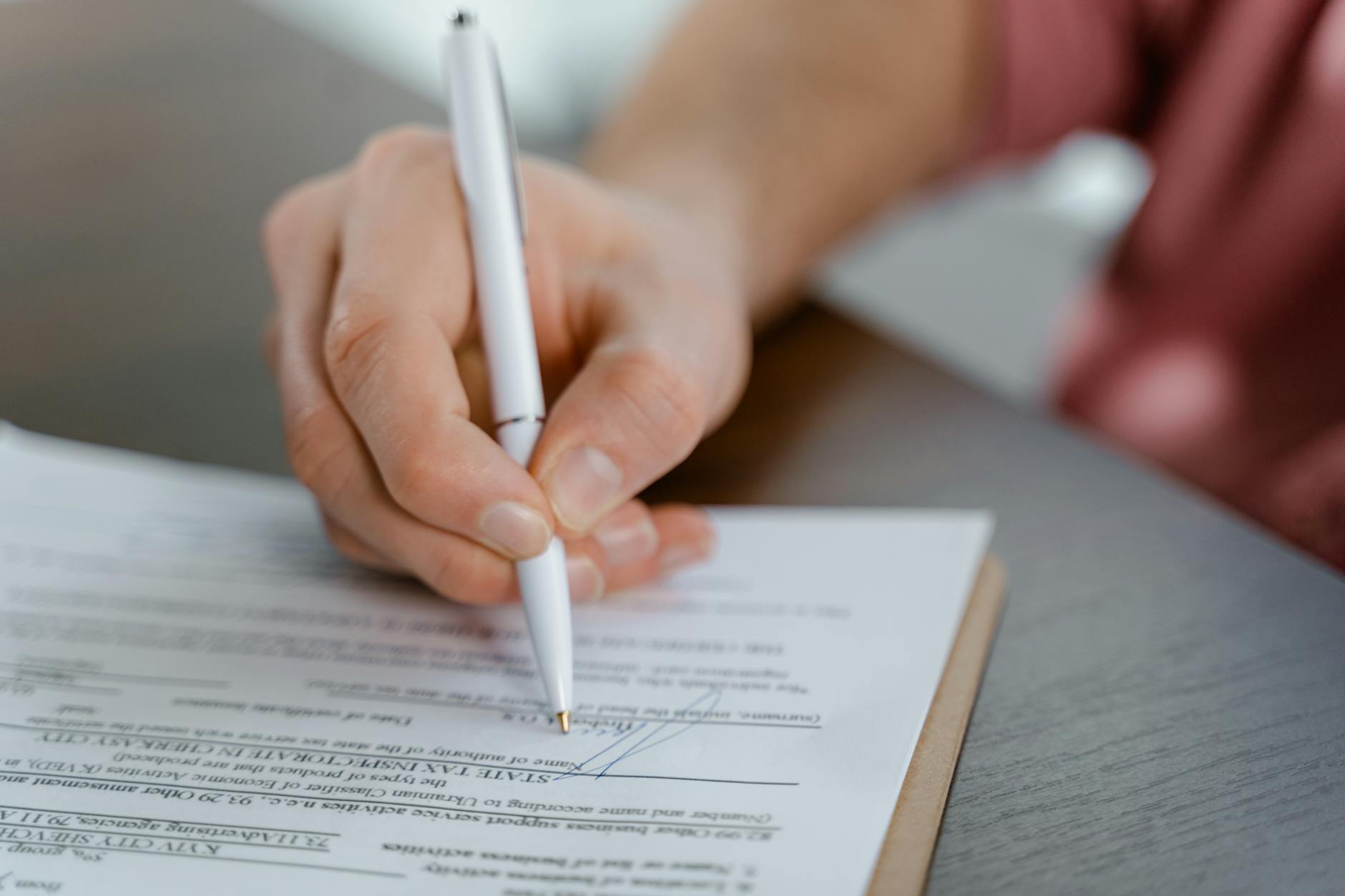person signing on a paper