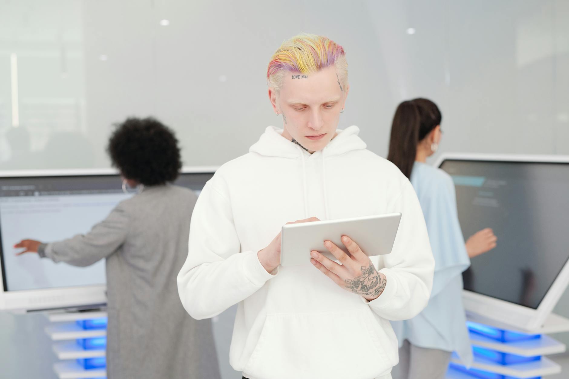 man in white hoodie using tablet