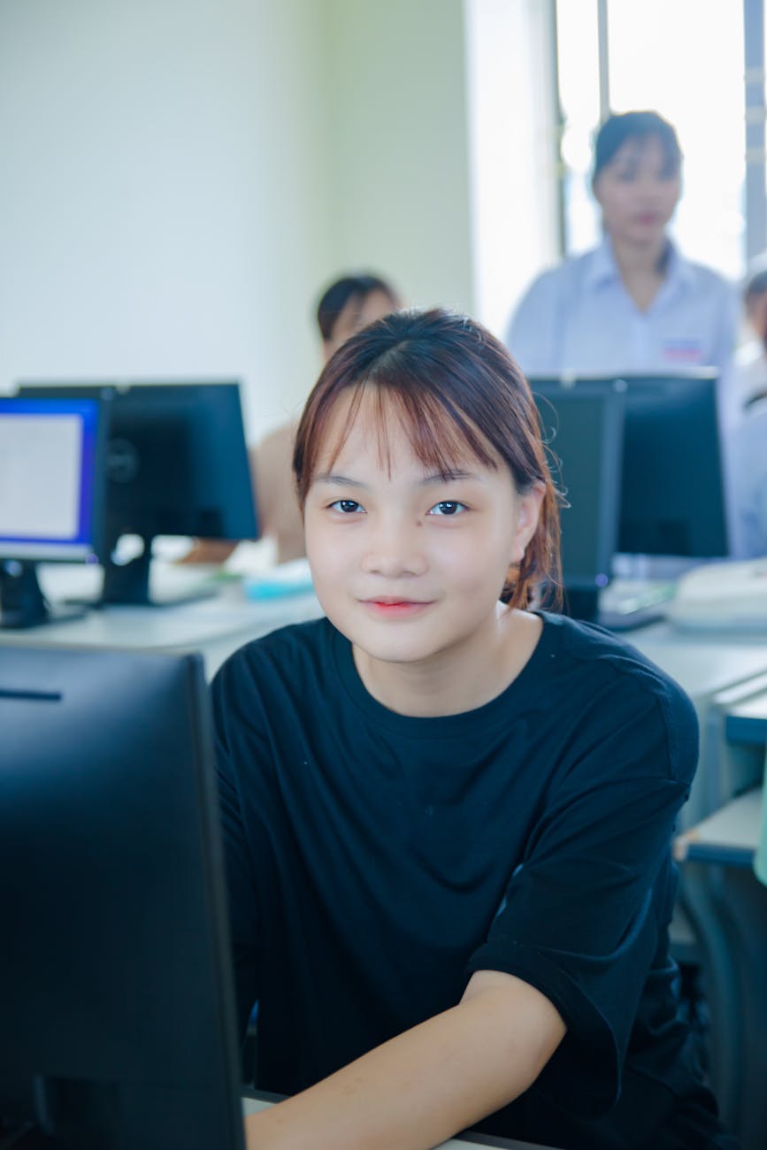 girl in black t shirt sitting behind computer