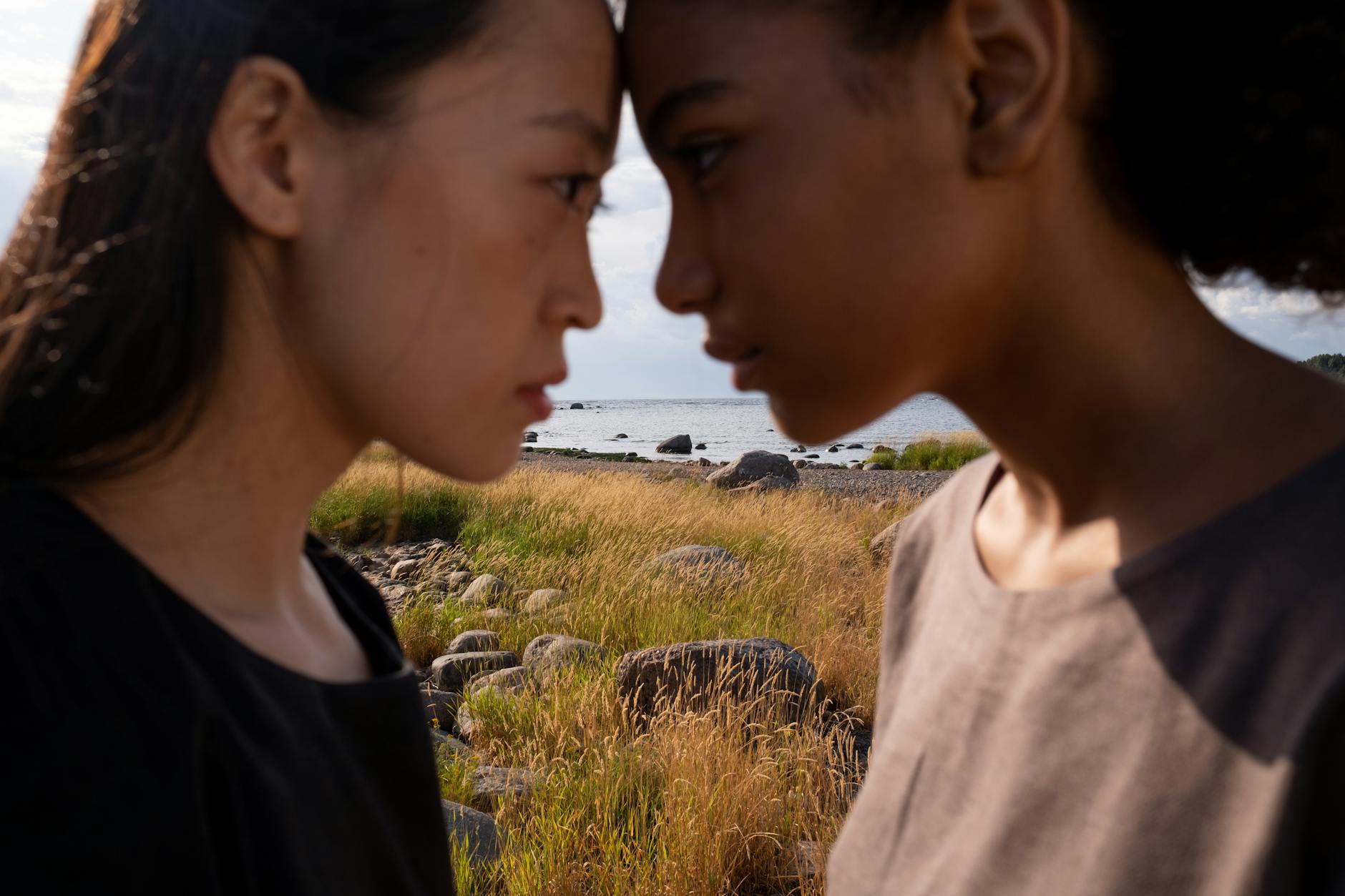 a side view of women touching heads