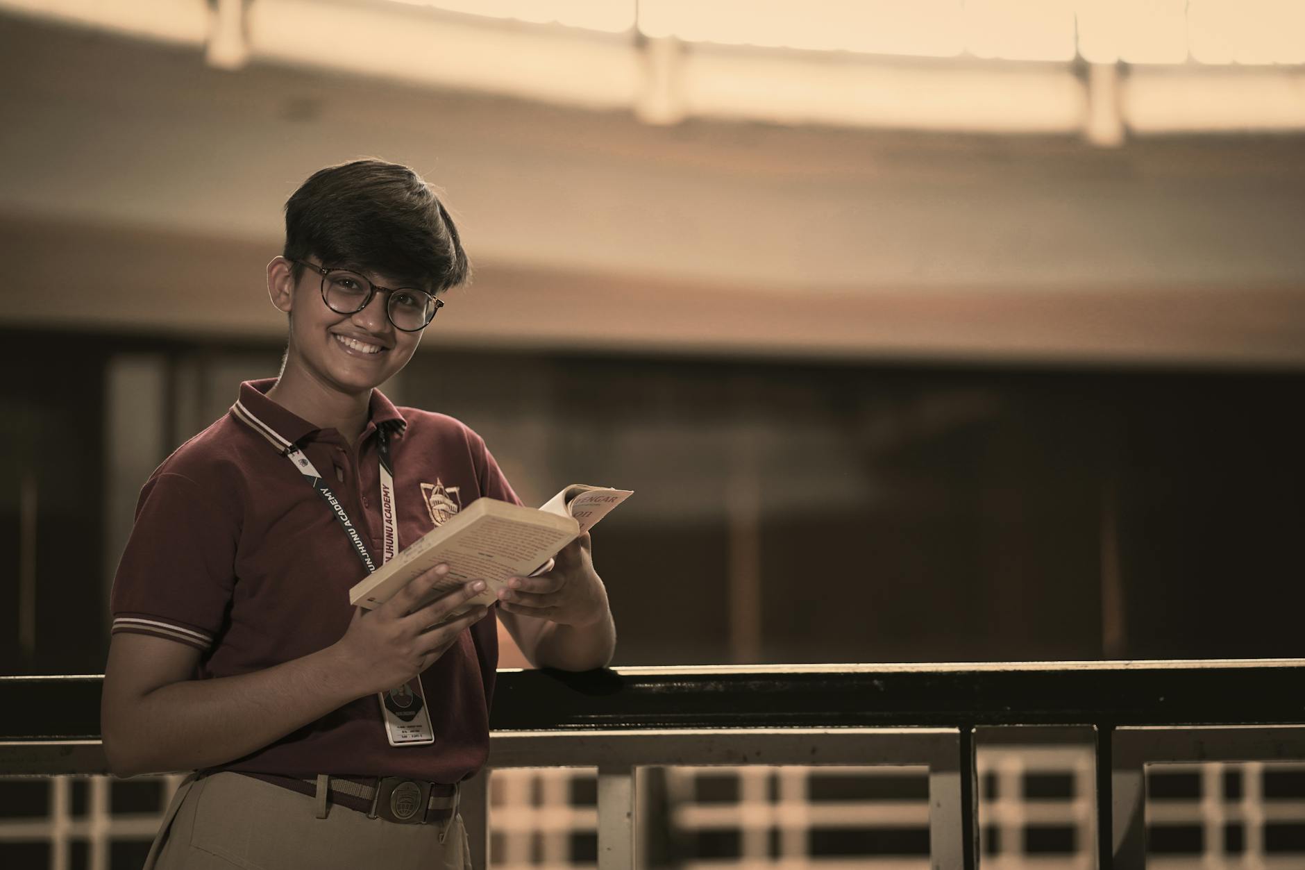 smiling student holding a book indoors