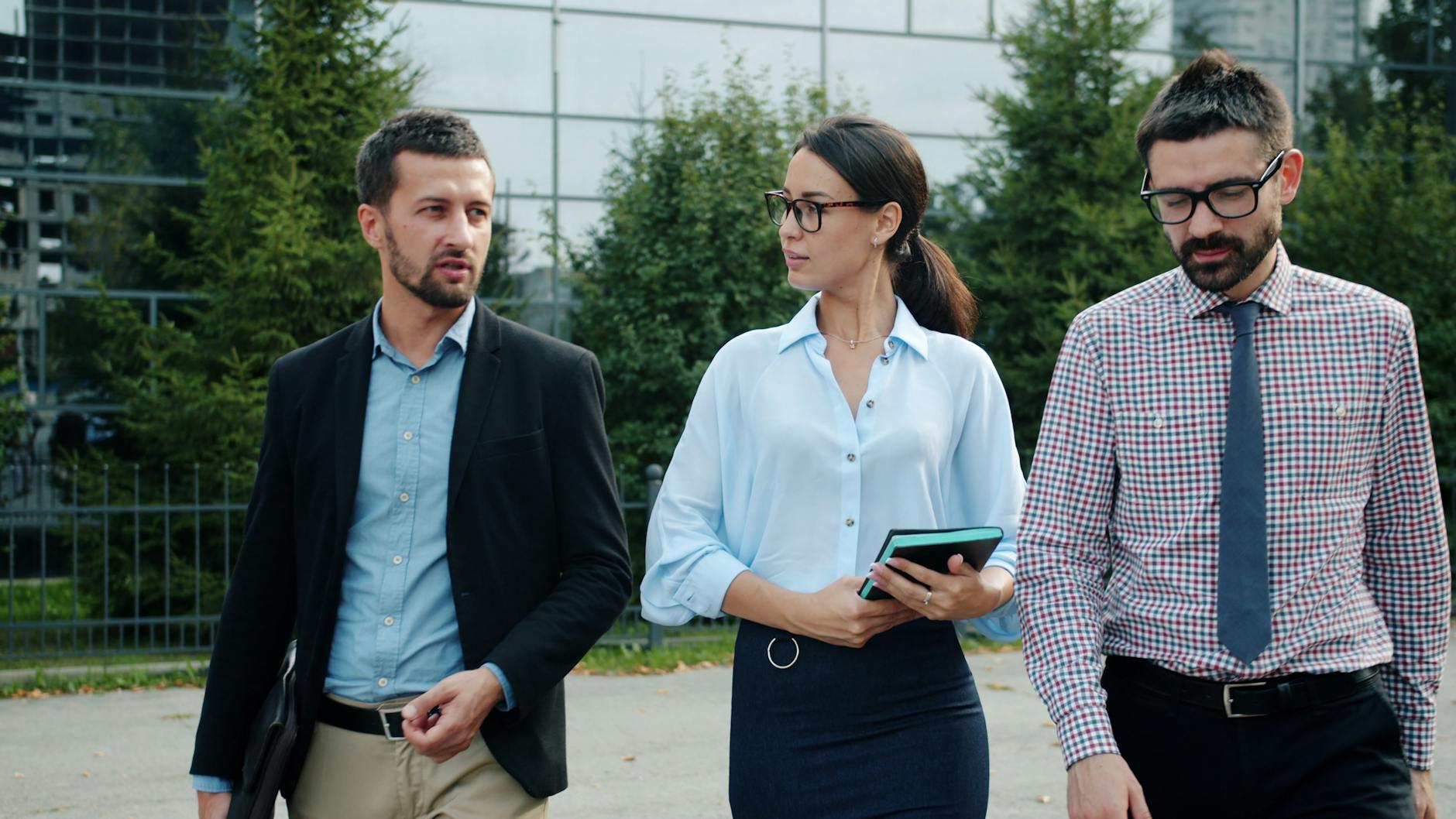 business professionals walking outdoors discussing
