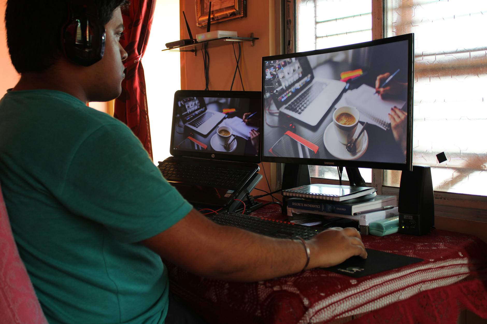 man in green t shirt sitting in front of computer