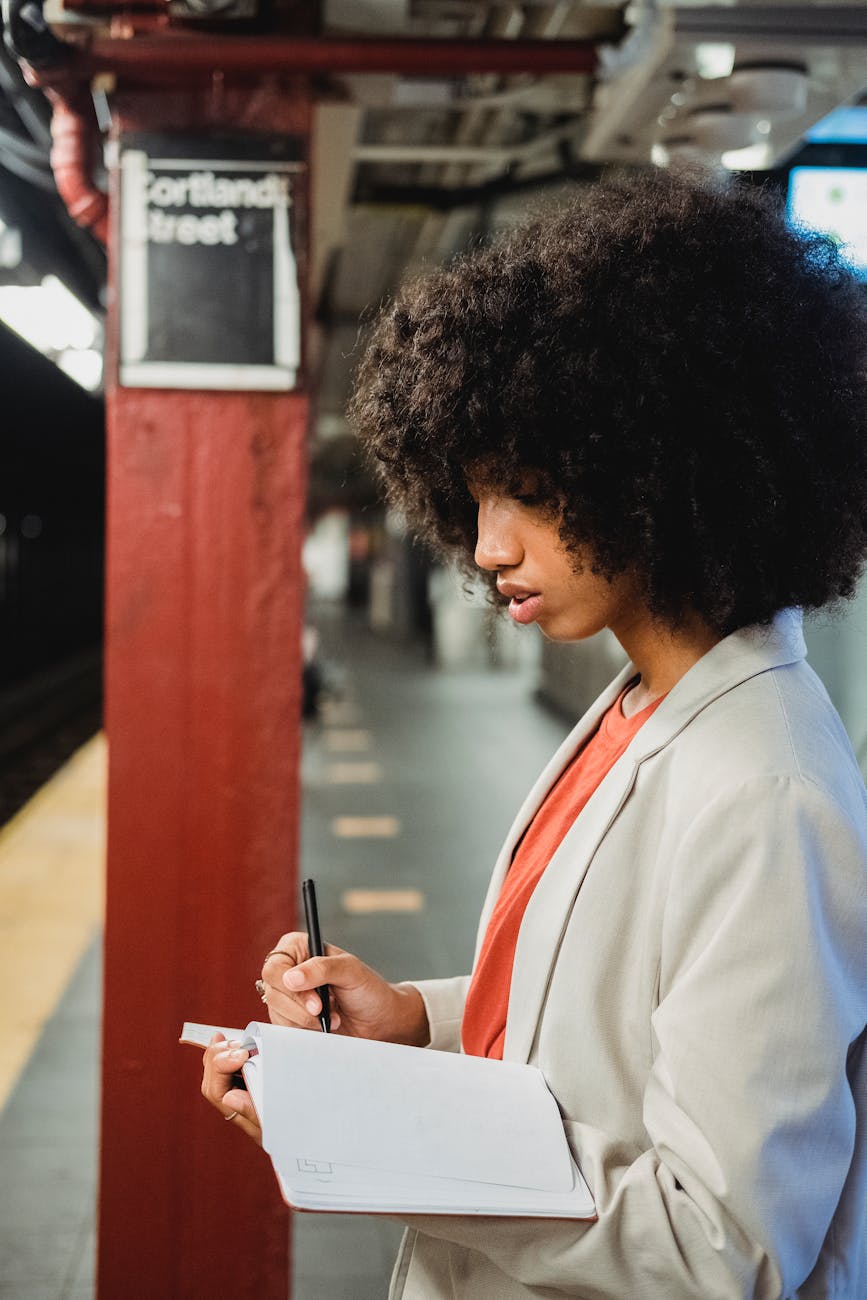 woman taking notes at train station