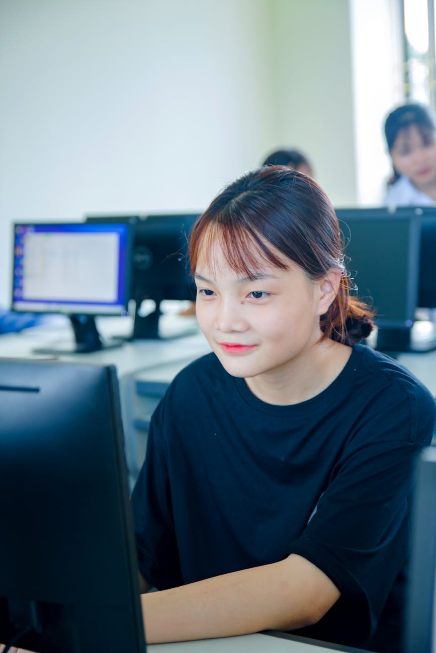woman in black t shirt using computer and smiling