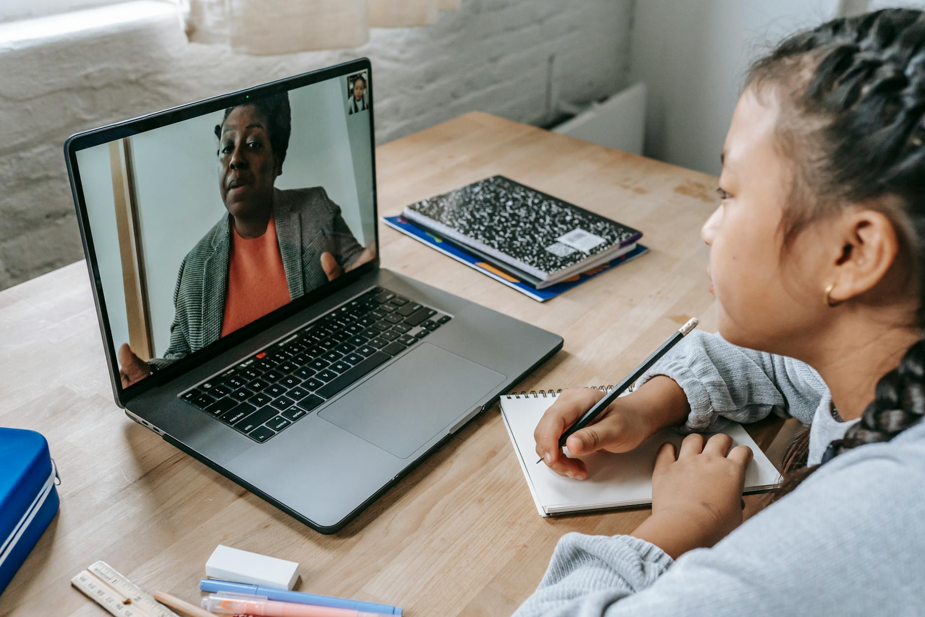 focused asian girl carefully listening explanation from teacher during remote studies