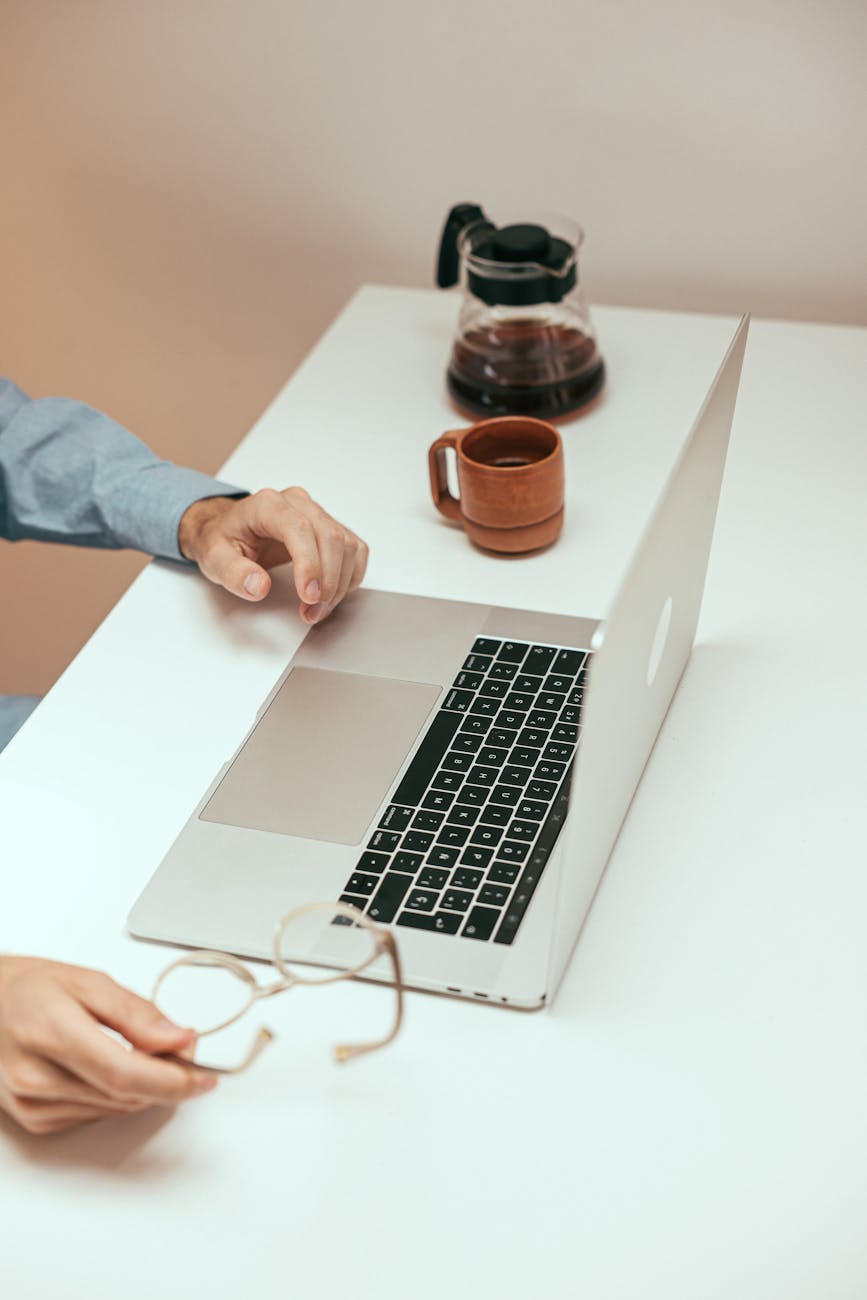 person using laptop on white table