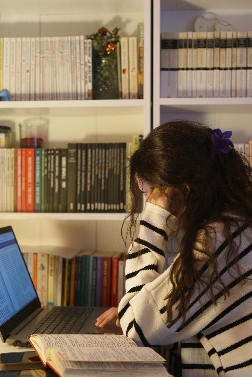 woman studying at home with books and laptop