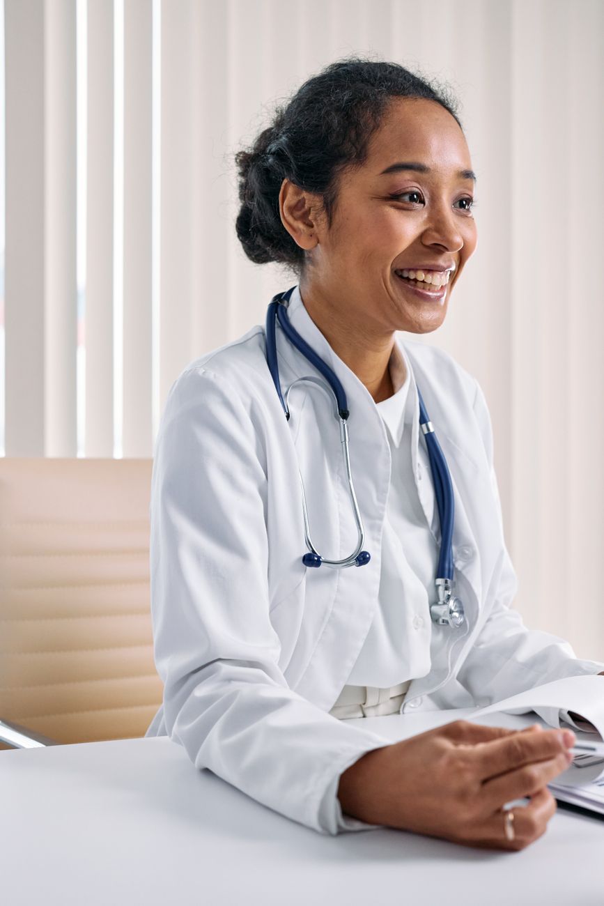 smiling doctor by table