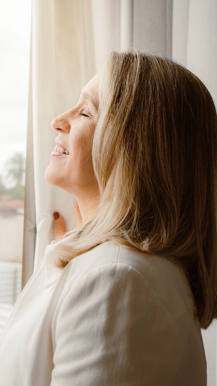 smiling woman by a window