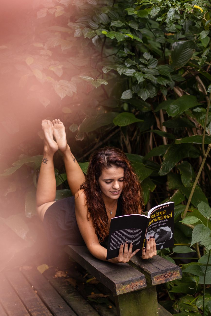 woman reading book on patio