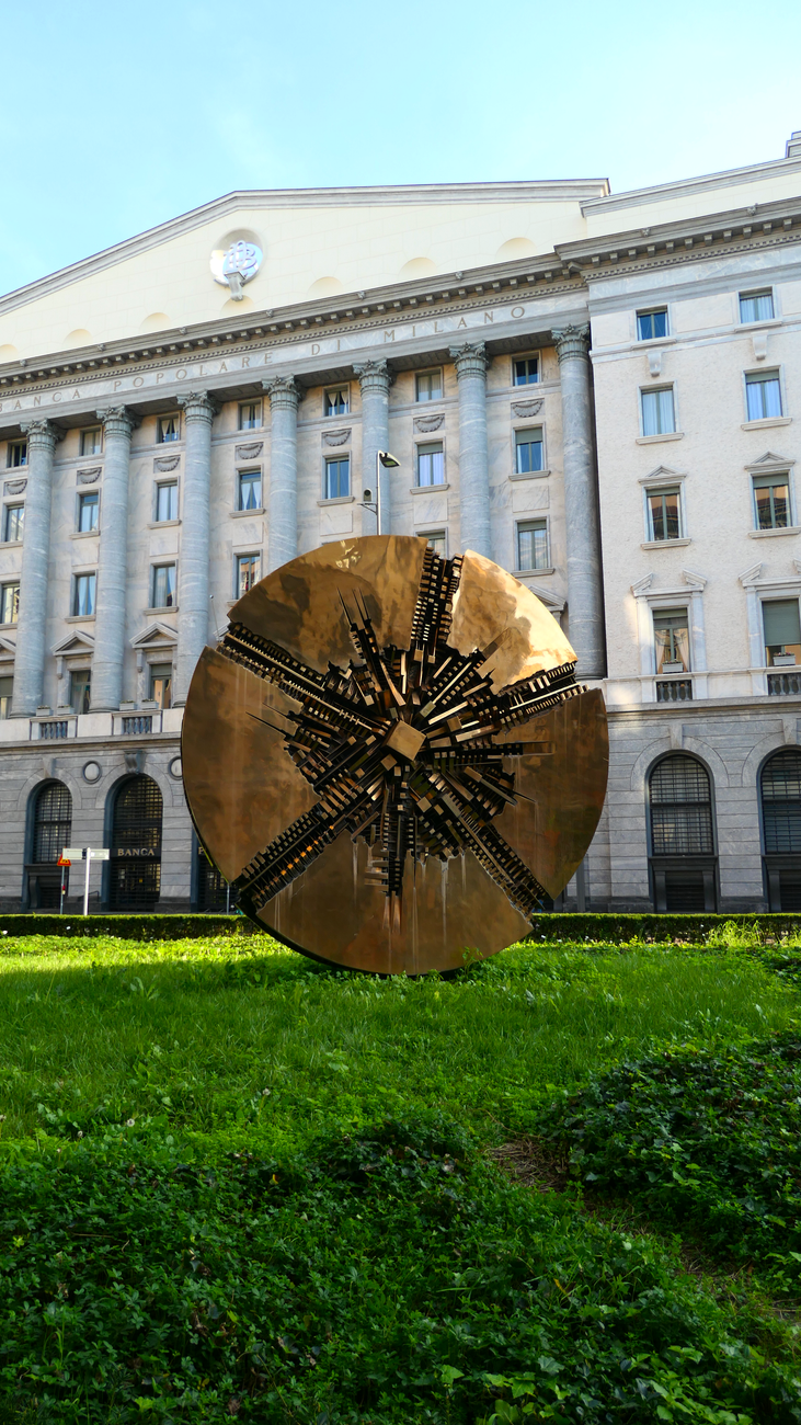 abstract bronze sculpture in milan s urban landscape