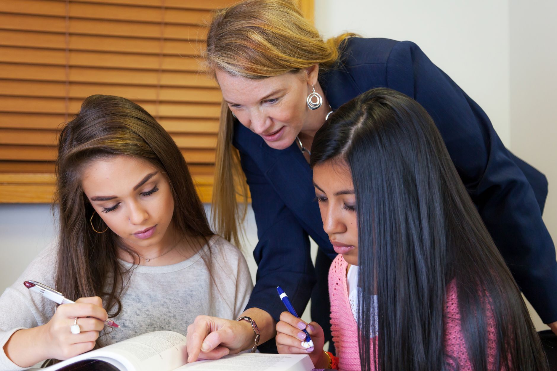 teacher assisting students in a classroom setting