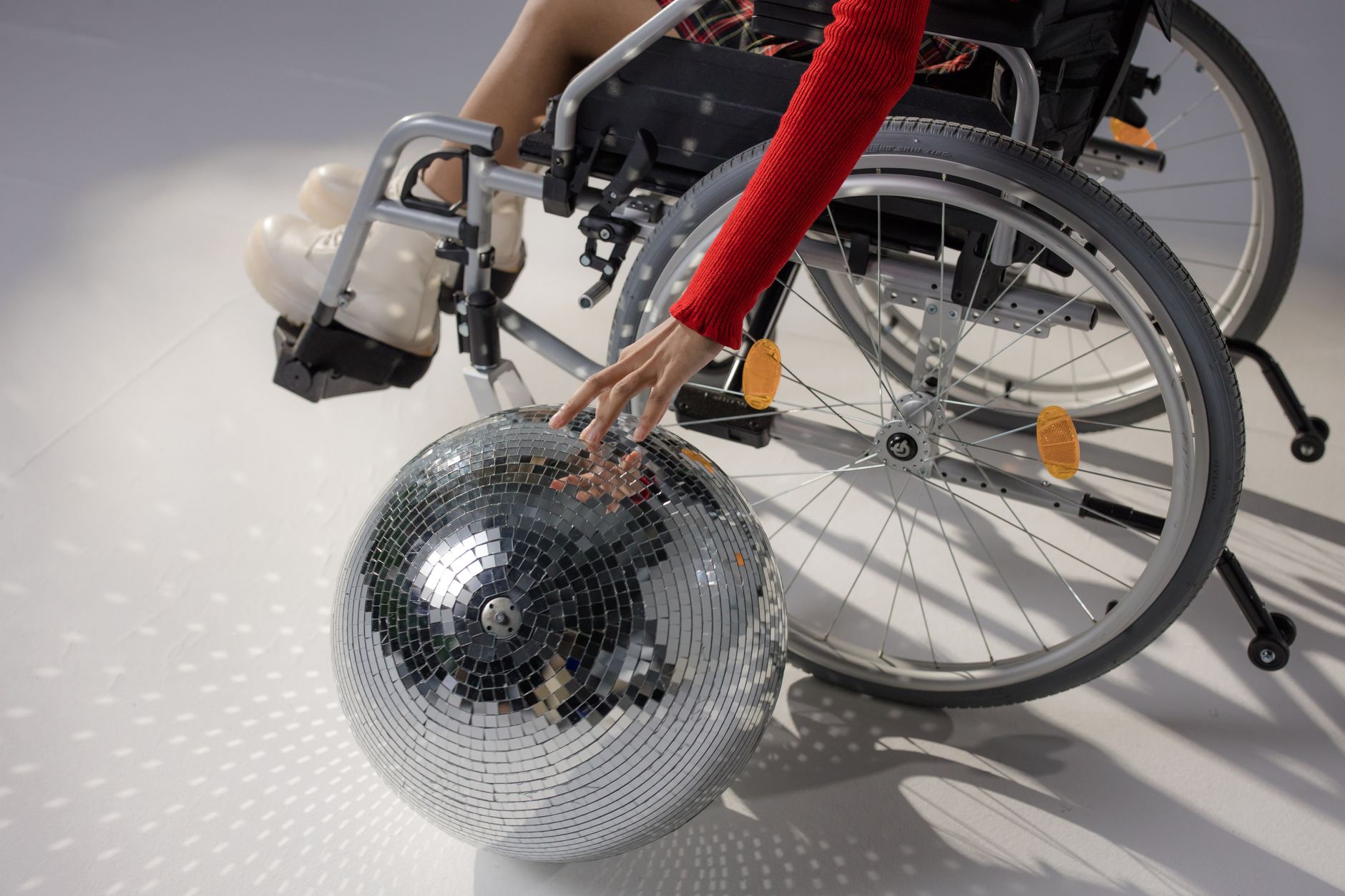 a person in a wheelchair touching a disco ball on the floor