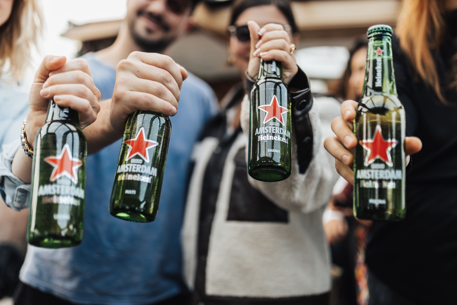 group of people holding bottles of beer