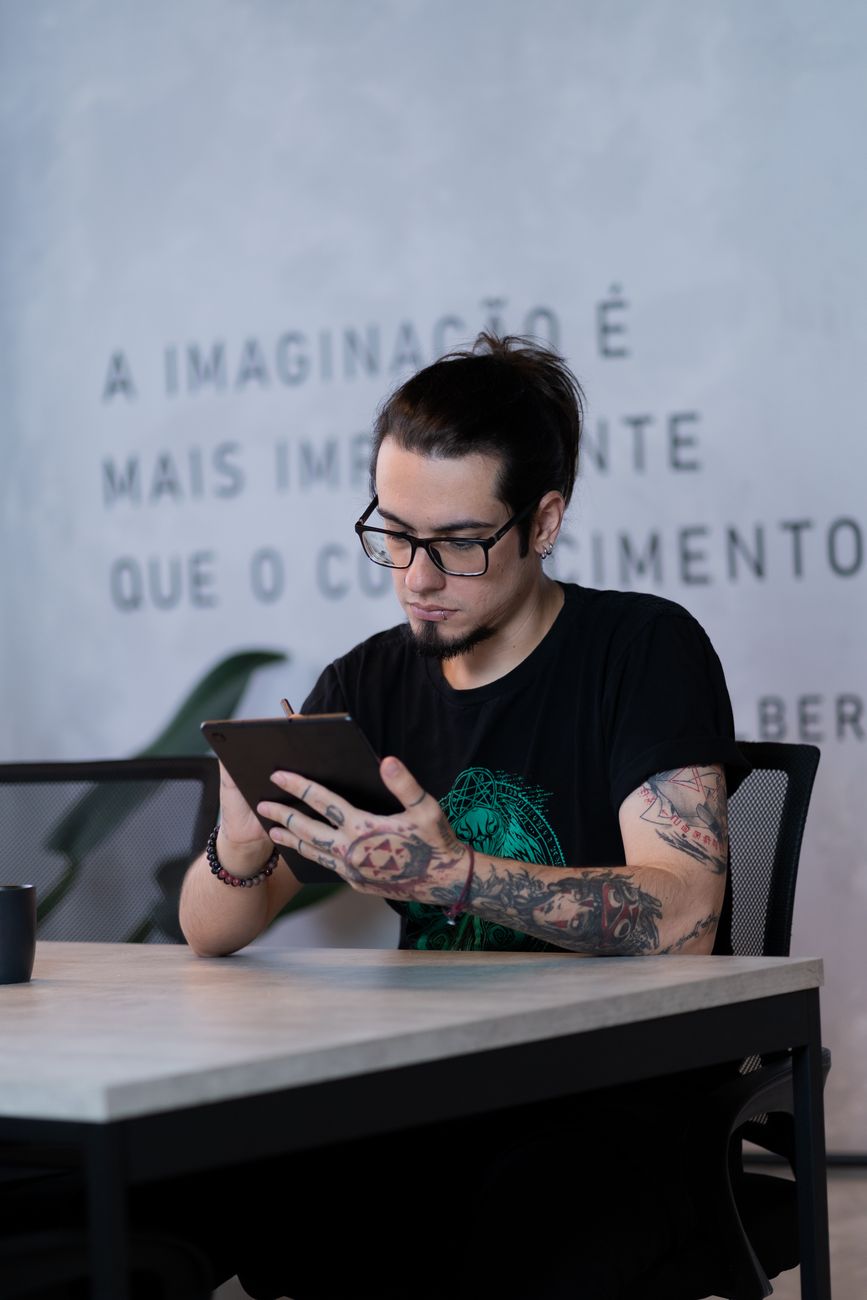 modern tattooed artist using tablet at desk