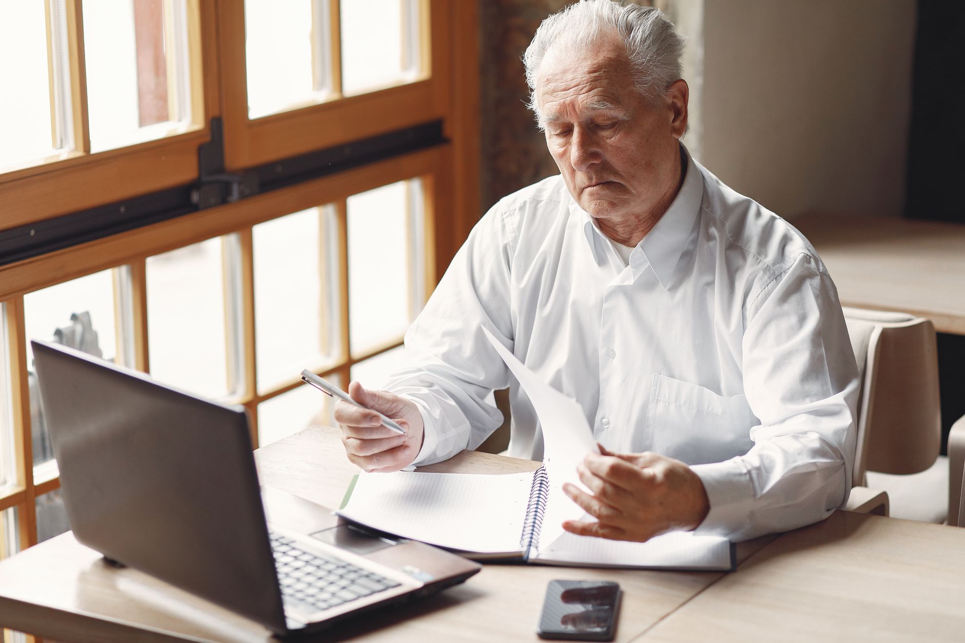 concentrated senior businessman working remotely in modern office