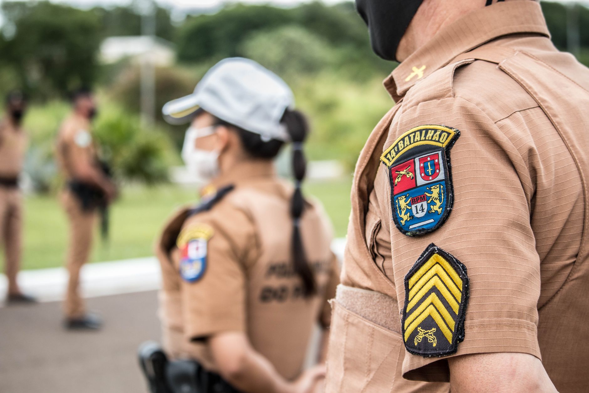 people in brown uniform standing on the road