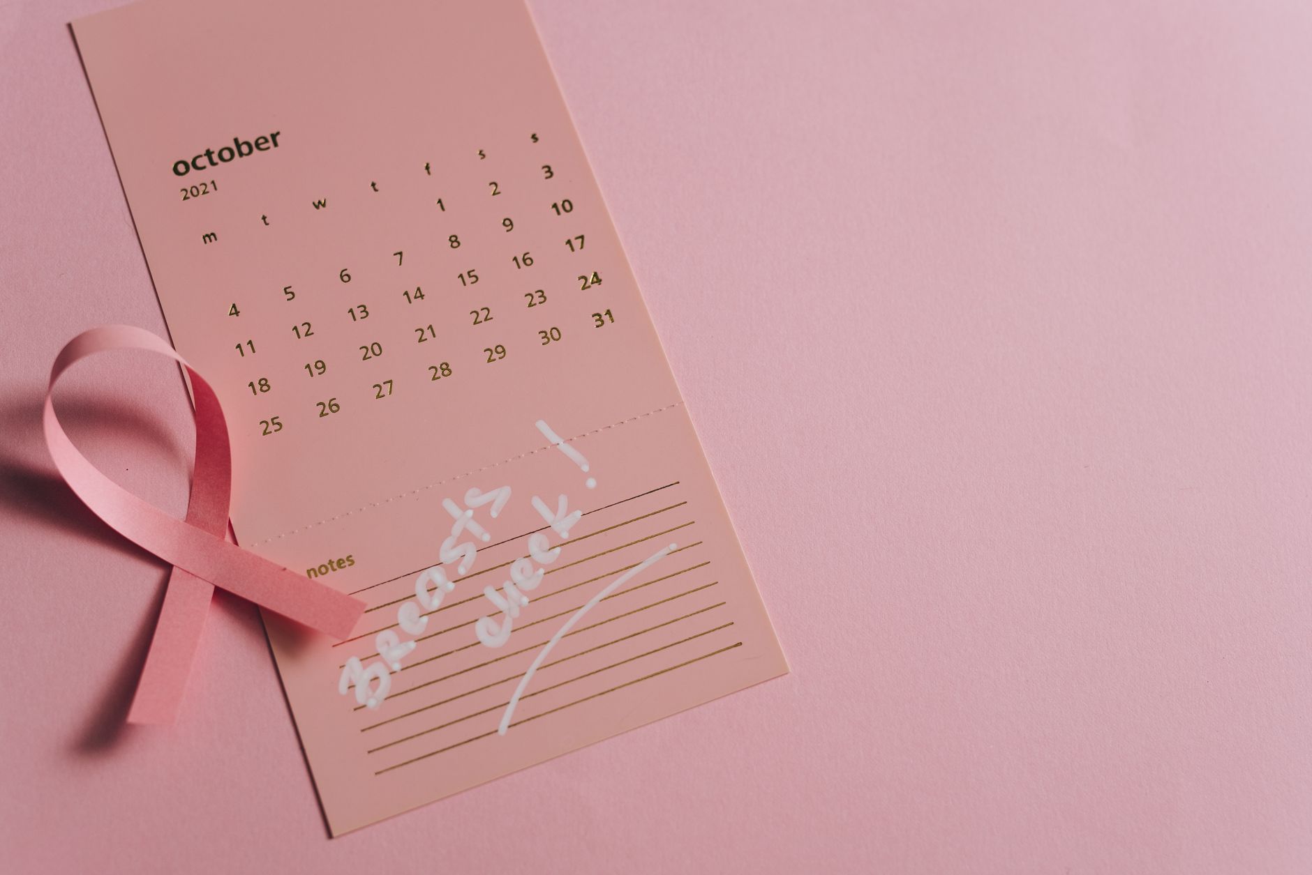 close up shot of a pink ribbon on a calendar