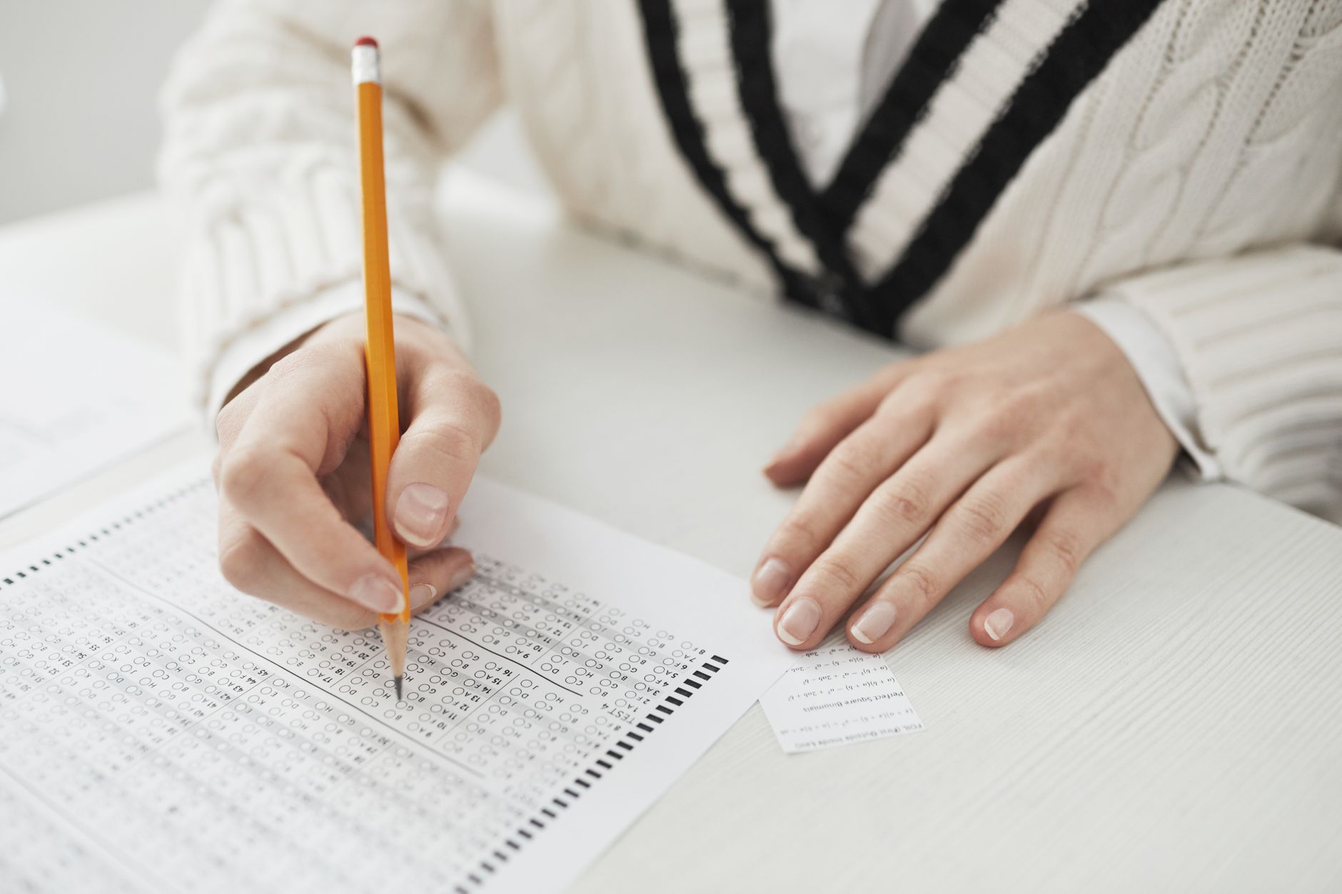 a person writing on paper while cheating